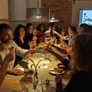 Menschen an einem Tisch beim Dinner, die zusammen anstoßen